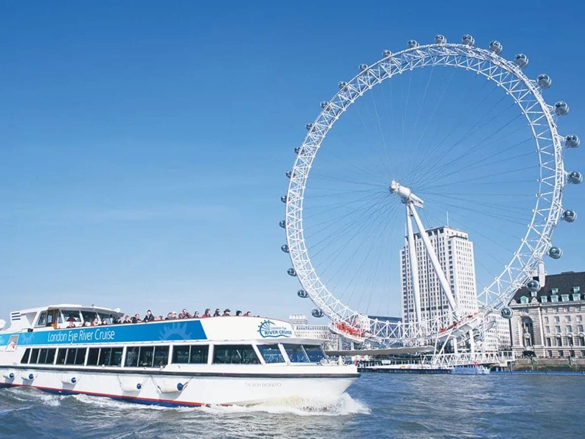 A Thames river cruise boat passing the London Eye