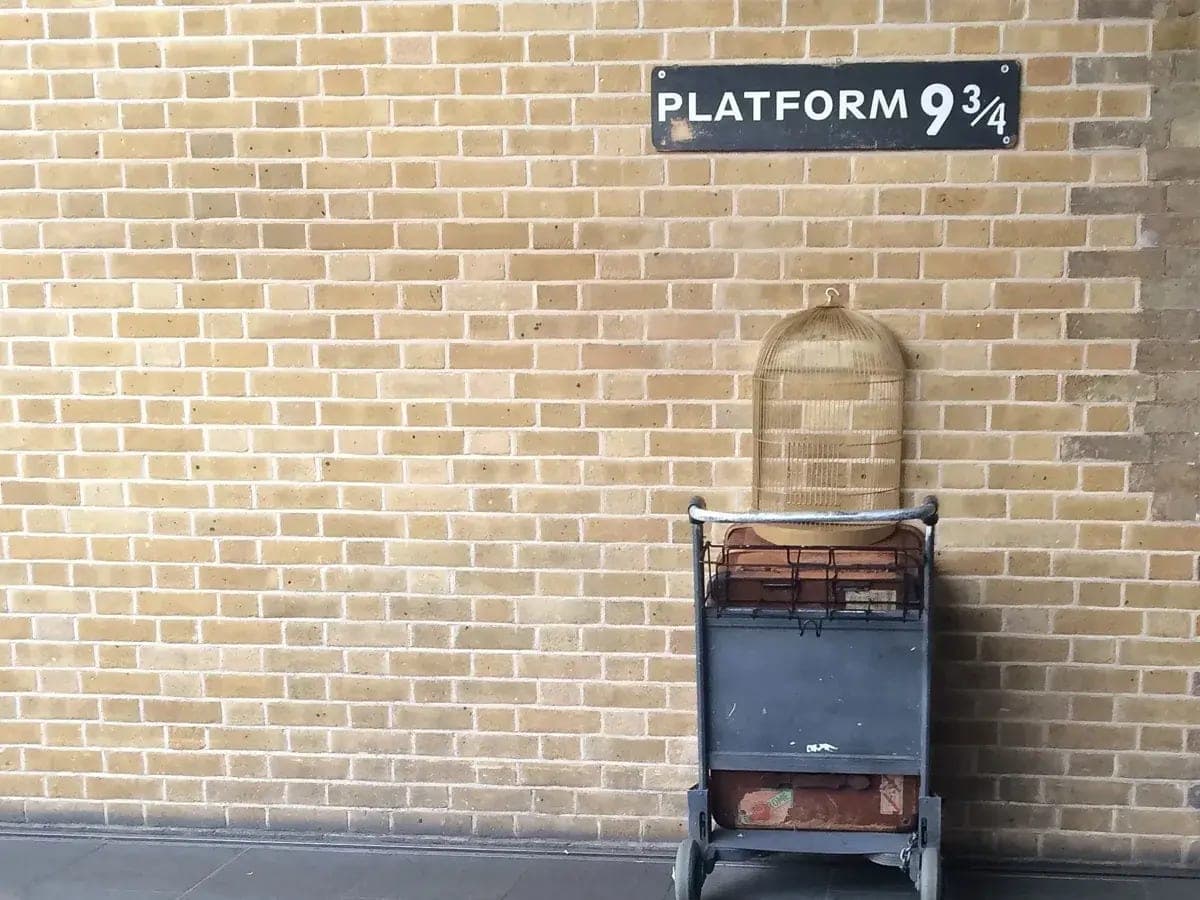The Platform 9¾ sign and luggage trolley set into a brick wall