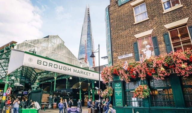 The green iron entrance of Borough Market with The Shard behind