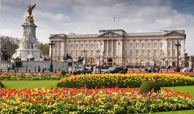 Buckingham Palace behind the Victoria Memorial and red and yellow tulip beds