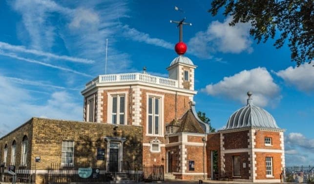 The red-brick Royal Observatory with its red time ball against a blue sky