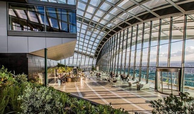 Plants and seating beneath the sweeping glass roof of the Sky Garden