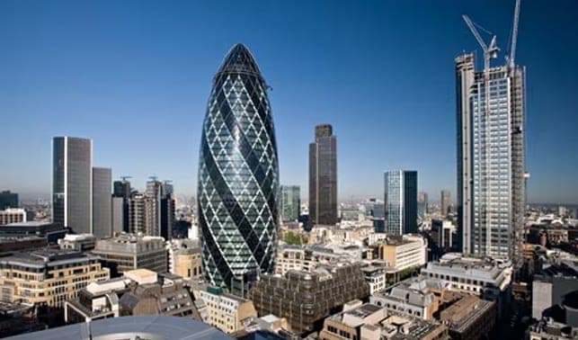 The curved glass tower of the Gherkin among City of London skyscrapers